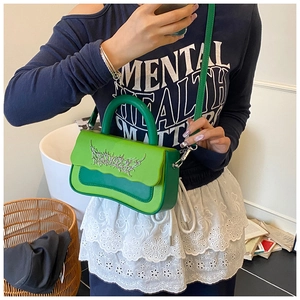 Detailed view of the green two-tone crossbody bag with gothic silver metal hardware