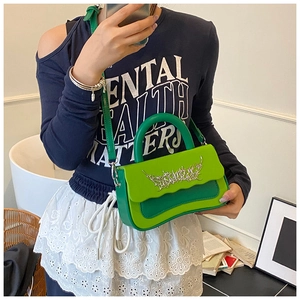 Detail of green PU leather handbag with wavy flap design and silver metal buckle