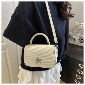 Detail of ivory woven textured square bag with rhinestone star charm and matching strap