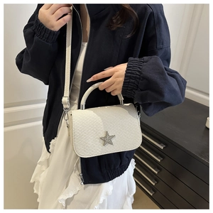 Macro detail of beige woven texture and star metal buckle on stylish crossbody bag