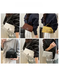 Detail showing crocodile pattern handbags in five colors with metal V-shape hardware
