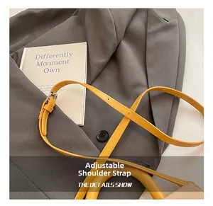 Close-up of adjustable ginger yellow leather shoulder strap with silver buckle detail