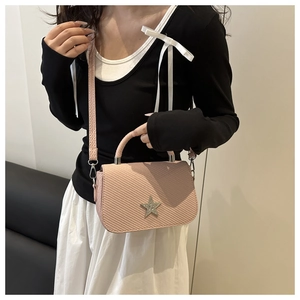 Close-up of pink crossbody bag featuring diagonal textured pattern and rhinestone star