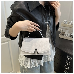 Detail showing white crocodile texture and silver A-shaped buckle on small square bag
