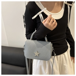 Detail of light blue saddle bag with rhinestone star and metallic handle