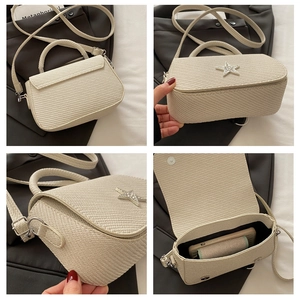 Detail view of beige woven handbag with rhinestone star and internal storage space