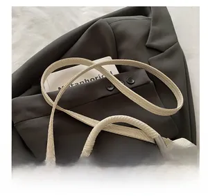 Detail des verstärkten Griffs und der Webstruktur einer beigen minimalistischen Tasche