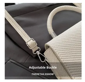 Close-up of beige woven bag adjustable strap with polished silver metal buckle hardware