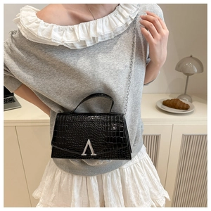 Close-up of black crocodile-embossed leather handbag with silver metallic A-logo buckle