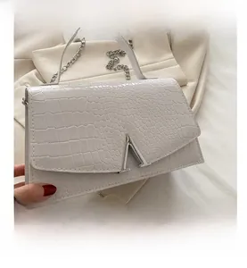 Detailed macro of white crocodile texture handbag with V-shape silver metal clasp