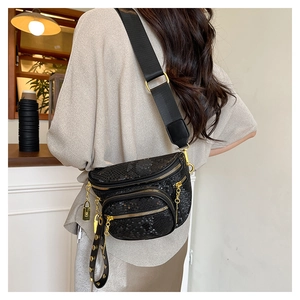 Detail der schwarzen Brusttasche mit Schlangenmuster, vielen Taschen und Gold-Metallteilen
