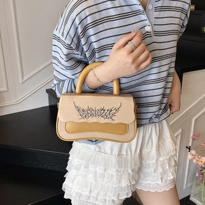 Fashionable contrast color handbag with metallic flame logo and curved base design