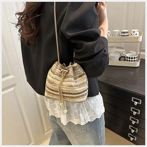 Détail du sac seau tissé avec rayures multicolores et élégants cordons ornés de perles