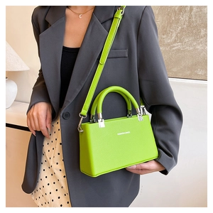 Macro detail of lime green litchi texture leather handbag with silver metal hardware