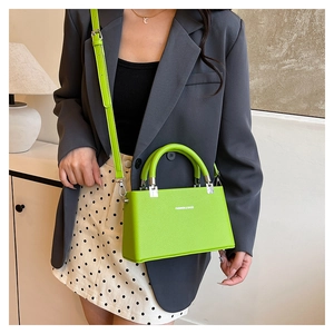 Close-up of lime green litchi texture box bag with fashion lettering and silver hardware