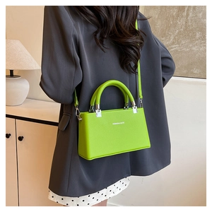 Bright green lychee grain handbag shown on person in a minimalist home setting