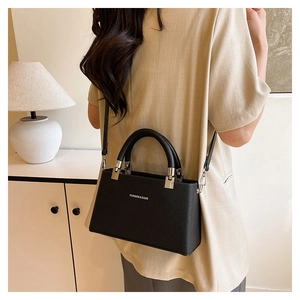 Close-up of black lychee grain leather handbag with silver Fashion & Bags text detail