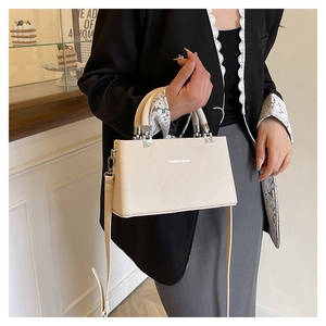 Detail of lychee pattern leather handbag in beige with silver hardware and shoulder strap