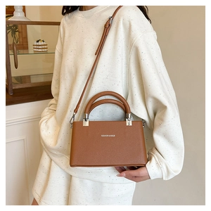 Detail view of brown lychee grain box bag with Fashion & Bags text and silver hardware