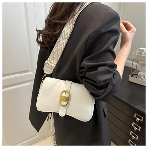 Close-up of white leather crossbody bag with gold buckle and geometric woven strap