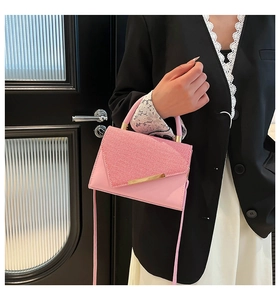 Pink woven texture handbag featuring gold metal trim and leather strap on model