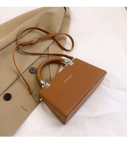 Close-up of caramel litchi grain leather handbag with Fashion & Bags text on trench coat