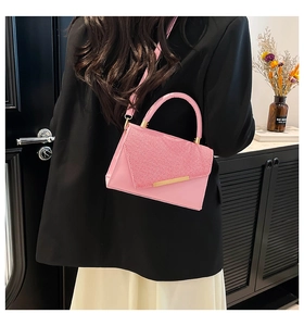 Pink crossbody bag featuring textured patchwork design and minimalist gold metal hardware