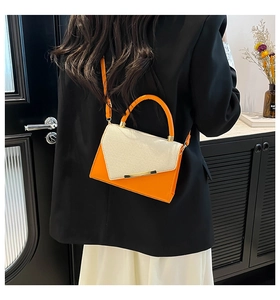 Detail view of orange leather and cream woven texture on the mini square bag