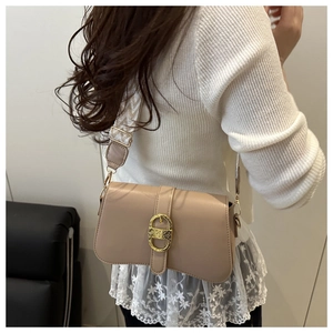 Close-up of minimalist apricot shoulder bag with a vintage gold buckle and stylish strap