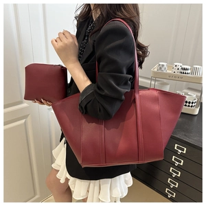 Detail shot of deep burgundy leather tote with matching pouch shown on a model
