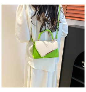 Detail of neon green patent leather and white woven texture on a modern crossbody bag