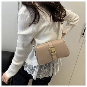 Close-up of beige baguette bag with gold buckle on model for styling and scale