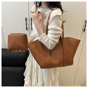 Detail view of large brown tote bag with matching zipper pouch in minimalist style