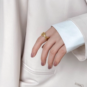 Minimalist hollow chain link ring in polished gold finish worn on finger for casual style
