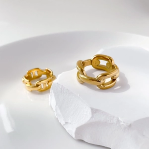 Detailed close-up of gold chain link rings with intricate textured engraving on stone