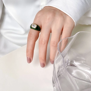 Detailed shot of Mobius ring featuring green enamel and a rectangular zircon stone