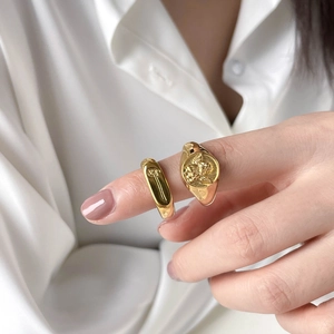Vintage gold angel relief signet ring and minimalist wide band set worn on finger