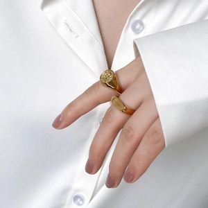 Close-up of vintage gold signet rings with angel relief and minimalist floral patterns