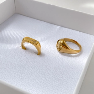 Detailed macro view of vintage gold signet rings with floral and relief coin engraving
