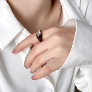 Elegant Mobius ring featuring purple enamel, gold plating and a rectangular crystal stone