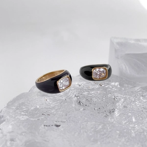 Macro detail of black enamel Mobius rings with rectangular cubic zirconia on ice props