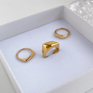 Primer plano detallado de un set de tres anillos geométricos dorados en un joyero
