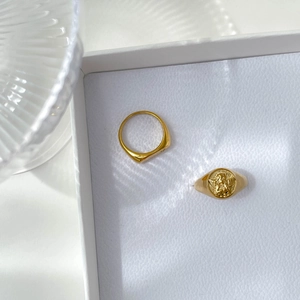 Detail of vintage gold signet rings featuring a 3D embossed angel cupid carving design