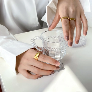 Tres anchos de anillos geométricos minimalistas de oro en la mano de modelo