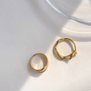 Détails de bagues dorées minimalistes aux designs lisses et irréguliers ondulés