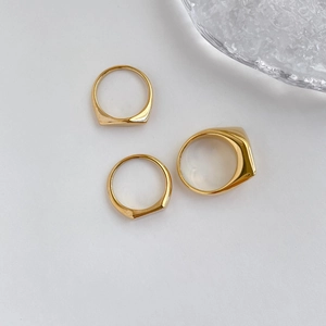 Vista detallada de anillos de sello dorados minimalistas con diseño geométrico facetado