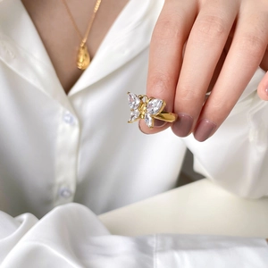 Bague papillon dorée élégante avec pierres en zircon sur une main de femme