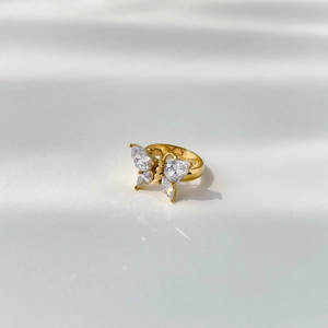 Vue rapprochée d'une bague papillon dorée avec quatre zircons de taille marquise
