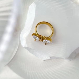 Détail de la bague papillon en or 18 carats avec zircons marquises sur une pierre texturée