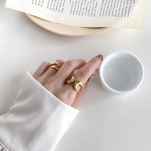 Detailed view of 18K gold plated minimalist rings with sleek abstract curved designs